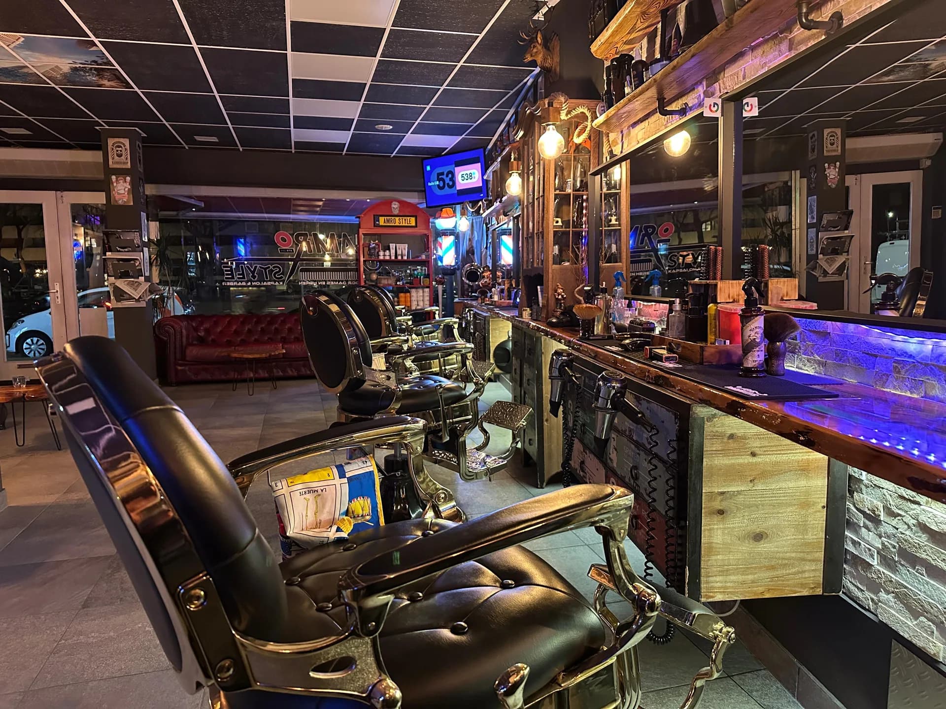 Barberstoelen voor de spiegels en houten werkbank bij Amro Style