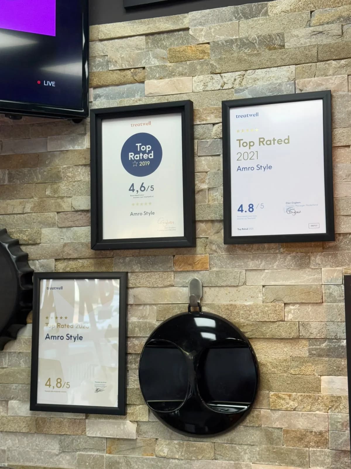 Treatwell Top Rated-certificaten van Amro Style aan de muur in de salon